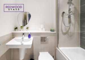 a bathroom with a sink and a shower and a toilet at BRAND NEW! 3 Bed 2 Bath House, NEAR HOSPITAL, With FREE x2 Parking & Wi-Fi By REDWOOD STAYS in Basingstoke