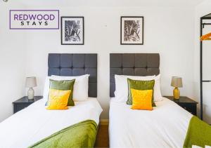 a bedroom with two beds with white and yellow pillows at BRAND NEW! 3 Bed 2 Bath House, NEAR HOSPITAL, With FREE x2 Parking & Wi-Fi By REDWOOD STAYS in Basingstoke