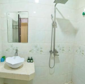 a white bathroom with a sink and a shower at Nguyen Dang Guesthouse in Sa Pa