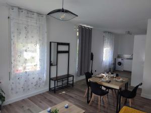 a living room with a table and chairs and a kitchen at Chambre privée in Tarbes