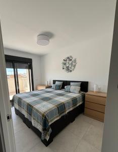 a bedroom with a bed with a plaid blanket at Casa Blu Blu - Your Holidayhome with pool near the Beach! in Santiago de la Ribera
