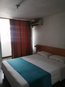 Un dormitorio con una cama grande y una ventana en HOTEL del OESTE B&B en Cali