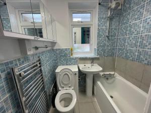 Double Room في Morden: حمام مع مرحاض ومغسلة وحوض استحمام