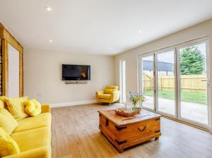 a living room with a couch and a table at City to Country Retreat Luxury Cottage with Hot Tub in Toppesfield