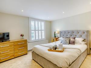 1 dormitorio con 1 cama grande y TV en City to Country Retreat Luxury Cottage with Hot Tub, en Toppesfield