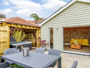 a backyard patio with a table and chairs at City to Country Retreat Luxury Cottage with Hot Tub in Toppesfield