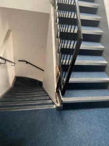 Kirkgate Aprt4 - Duplex Relocations في ويكفيلد: مجموعة من السلالم في مبنى به سجادة زرقاء