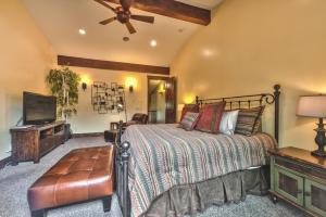 a bedroom with a bed and a flat screen tv at Badgerland Park City - Summer Escape with Year-Round Recreation, Mountain Trail and Private Hot Tub! in Park City