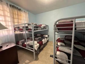 Cette chambre comprend deux lits superposés et un bureau. dans l'établissement 3BR, 1BA in Cepeda, Up to 20 Guests near Ocean Park Beach, à San Juan