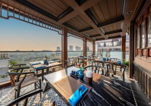 a balcony with tables and chairs and a view of the city at Hanoi Old Quarter Hotel in Hanoi