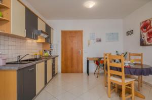 eine Küche mit einem Tisch und einem Esszimmer in der Unterkunft Apartments Kvarner in Malinska