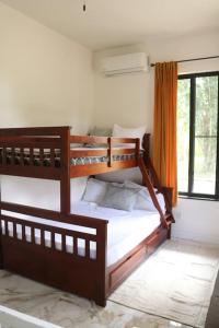 2 Etagenbetten in einem Zimmer mit Fenster in der Unterkunft Central Oasis Private Pool BBQ in Belmopan