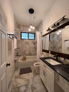 ein Badezimmer mit einem Waschbecken, einem WC und einer Badewanne in der Unterkunft Central Oasis Private Pool BBQ in Belmopan