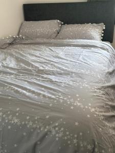 a bed with white sheets and stars on it at Centre reache in Southend-on-Sea
