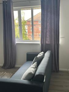 ein Sofa im Wohnzimmer mit Fenster in der Unterkunft Centre reache in Southend-on-Sea