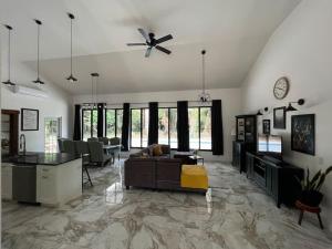 a living room with a couch and a ceiling fan at Central Oasis Private Pool BBQ in Belmopan