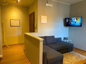 a living room with a couch and a tv on the wall at Appartamento La Rocca in Cesena
