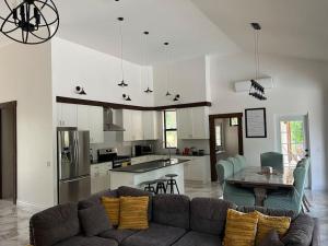 ein Wohnzimmer mit einem Sofa und einer Küche in der Unterkunft Central Oasis Private Pool BBQ in Belmopan