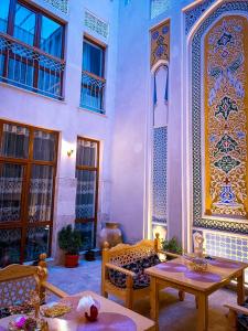 une chambre avec une table et des chaises et un bâtiment dans l'établissement Meros Hotel, à Boukhara