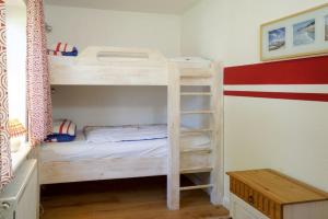 a bedroom with two bunk beds and a table at Pastors Stuv in Uelvesbüll