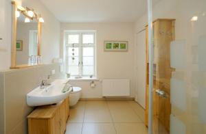 a bathroom with a sink and a toilet and a shower at Pastors Stuv in Uelvesbüll