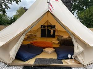 uma tenda com 3 camas e uma cozinha no interior em The Elm: Luxury Bell Tent with private bathroom em Toppesfield
