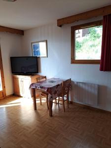 une salle à manger avec une table et une télévision dans l'établissement Appartement avec balcon - 2 personnes, à Puy-Saint-Vincent