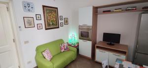 a living room with a green couch and a television at Casa Giuseppina Lecce in Lecce
