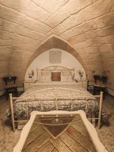 1 dormitorio con 1 cama grande en una pared de piedra en Stella House, en Fasano