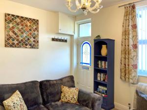 a living room with a couch and a book shelf at Cosy and convenient cottage in Bishop Auckland