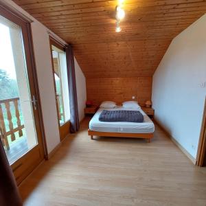 Gite De La Mortagne في Mortagne: غرفة نوم مع سرير في غرفة مع نوافذ