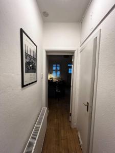 a hallway with a picture on the wall and a hallwayngthngthngthngthngth at Trendy artisan cottage in Stoneybatter near Dublin City centre in Dublin