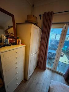a kitchen with a dresser and a large window at Trendy artisan cottage in Stoneybatter near Dublin City centre in Dublin