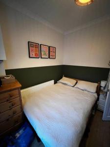 a small bedroom with a bed and a dresser at Trendy artisan cottage in Stoneybatter near Dublin City centre in Dublin