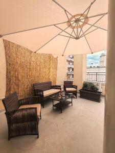 a patio with furniture and a large umbrella at Stella House in Fasano