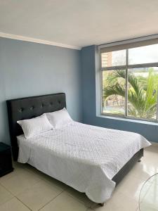 a bedroom with a large bed and a window at Hotel Estefanía Princess 84 in Barranquilla