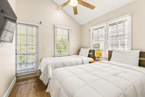 a white bedroom with two beds and windows at Harbor Hideaway Villa 7066 in Duck Key