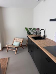 uma cozinha com um lavatório e uma bancada de madeira em Van Heeckeren City Centre Studios Nes em Nes