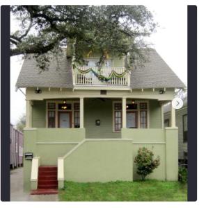 a green house with a balcony on top of it at India House Hostel in New Orleans