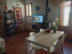 Casita Mona y Acogedora في ألكواس: غرفة طعام مع طاولة وكراسي وتلفزيون