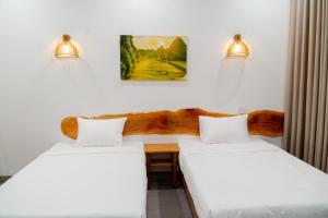 2 Betten neben einem Schreibtisch in einem Zimmer in der Unterkunft Lala Boutique Villas in Ninh Bình