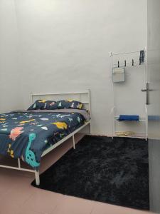 1 dormitorio con cama y alfombra negra en Maileyna Homestay 1.0, en Alor Setar