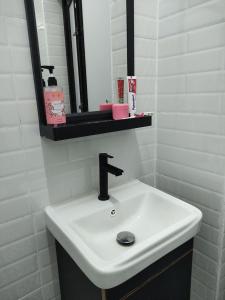 a white sink in a bathroom with a mirror at Maileyna Homestay 1.0 in Alor Setar