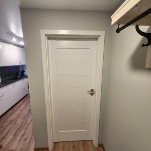 eine weiße Tür in einem Zimmer mit einer Küche in der Unterkunft Butas Sedos gatvėje in Telšiai
