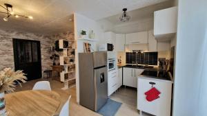 eine Küche mit einem Kühlschrank aus Edelstahl und einem Tisch in der Unterkunft Appartement Le Welcome in Argelès-Gazost