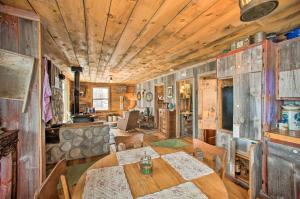 a dining room with a table and a living room at Secluded Powersville Cabin 25 Mi to Lake Paho! 