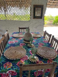 a table with plates and a pot on top of it at Namahamade Lodge Restaurante & Beach Bar in Mossuril