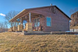 a small wooden house on top of a hill at Secluded Powersville Cabin 25 Mi to Lake Paho! 