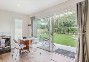 a kitchen and dining room with a sliding glass door at City to Country Retreat Luxury Lodges with Hot Tub, BBQ, Fire Pit in Toppesfield