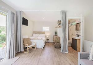 a bedroom with a bed and a living room at City to Country Retreat Luxury Lodges with Hot Tub, BBQ, Fire Pit in Toppesfield